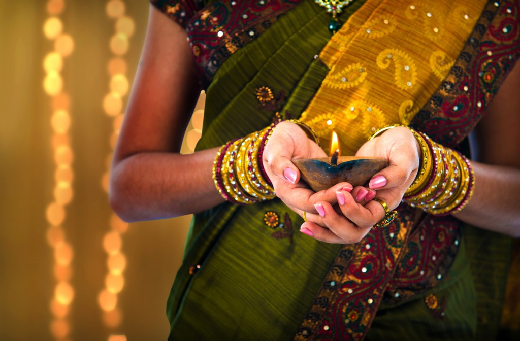 Female holding oil lamp during Diwali | Photo Credit: Shutterstock