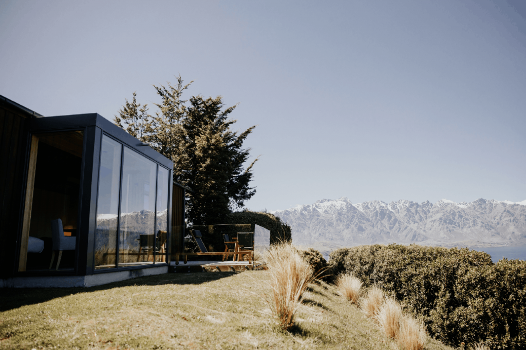 Image of Azur Lodge Exterior in the foreground, mountains in the background.