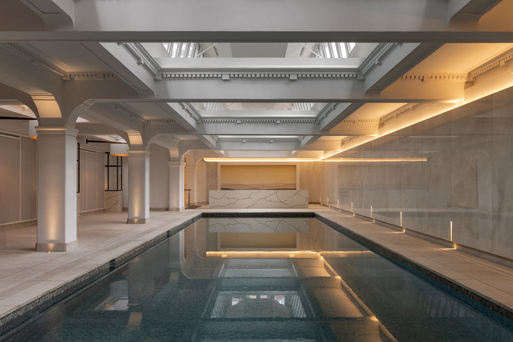 Image of the Capella Sydney Wellness Pool surrounded by marble floors and walls, skylight ceilings, and arches.