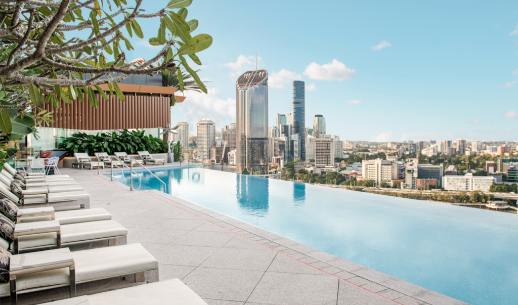Image of the rooftop pool at the Emporium Hotel South Bank with the South Brisbane city skyline in the background.