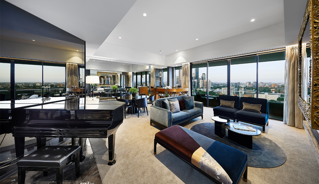 Image of the Frangipani Suite at the Emporium Hotel South Bank with the view of Brisbane city skyline out the windows in the background.