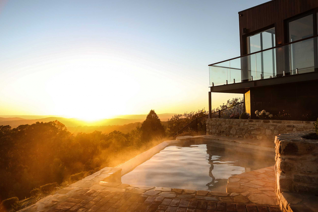 Image with Sequoia Lodge Artesian Hot Pools in the foreground, sunset over the mountains in the background.