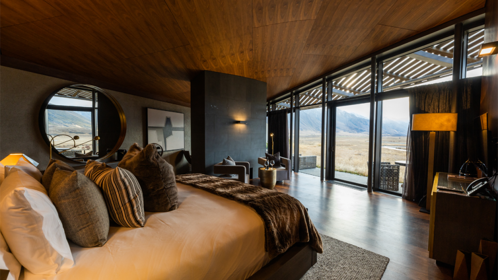 Image of the Ribbonwood Lodge Suite at The Lindis with mountains and grassland outside the windows in the background.