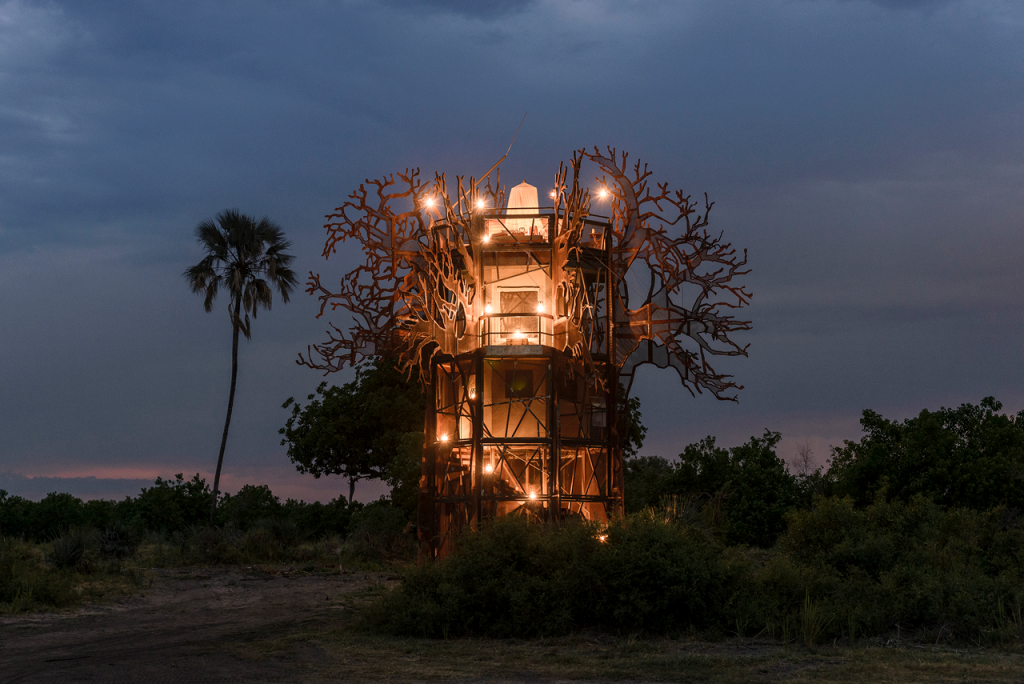 Image of the three story Baobob Sculpture at night.